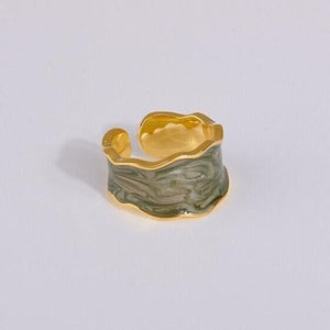 A set of three cocktail rings with gold plating and multicolored enamel, displayed against a white background.