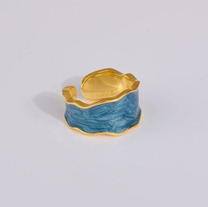 A set of three cocktail rings with gold plating and multicolored enamel, displayed against a white background.