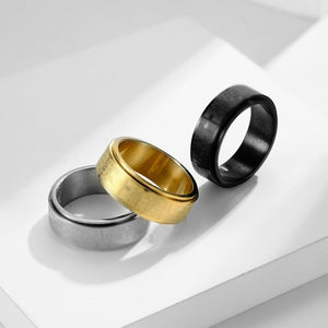 Three rings in gold, silver, and black on a light gray background