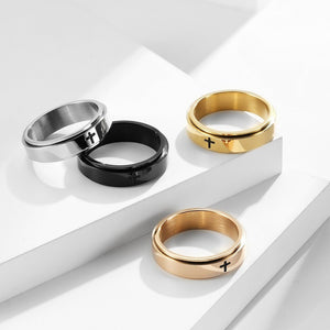 Four rings in gold, silver, black, and rose gold on a white background