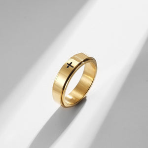 A collection of four rings, two with a black finish and two with a gold plating. Each ring features a cross symbol on the top surface.