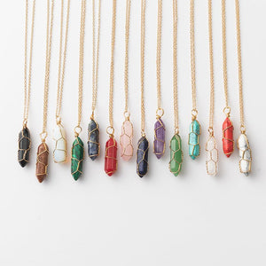 Necklaces with various colored stone pendants on gold chains against a white background