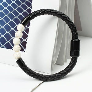 A multicolor beaded leather rope bracelet with gold plating on a textured background.