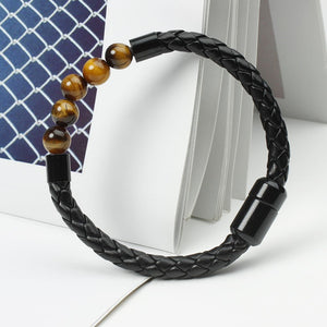 A multicolor beaded leather rope bracelet with gold plating on a textured background.
