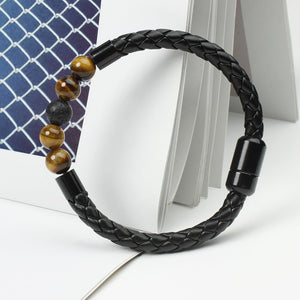 A multicolor beaded leather rope bracelet with gold plating on a textured background.