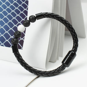 A multicolor beaded leather rope bracelet with gold plating on a textured background.