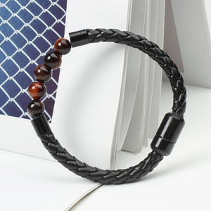 A multicolor beaded leather rope bracelet with gold plating on a textured background.