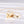 Gold locket necklace with letter and envelope charm on a white background