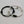 Two bracelets, one black and one white, with engraved names on a light gray background.