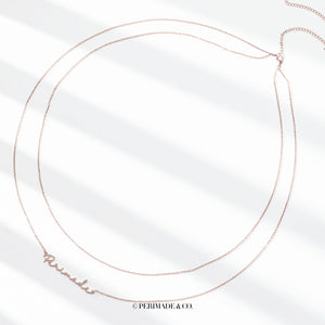 A close-up image of a person wearing a gold-colored double chain belly chain with customizable text.