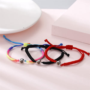 Four colorful bracelets with metal beads on a light pink surface.