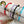 Set of colorful bracelets on a white surface with a pink background