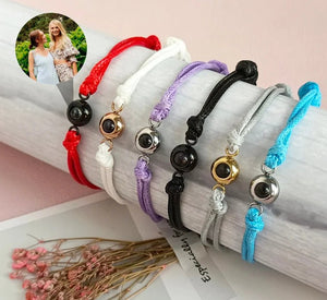 Set of colorful bracelets on a white surface with a pink background