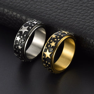 Two rings with star designs on a black textured surface