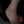 Silver anklet on a foot against a dark background