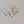 Three pairs of cross-shaped earrings in gold, silver, and gold on a gray background.