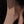 Gold anklet on a person's ankle against a dark background