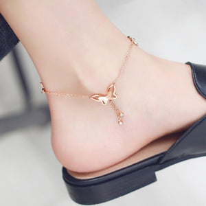 Rose gold anklet on a foot with a blurred background