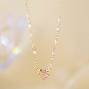 Necklace with a heart-shaped pendant and pearl beads on a soft background