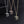 Three cross-shaped pendants on chains against a dark background