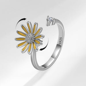 Silver ring with a yellow flower design on a white background
