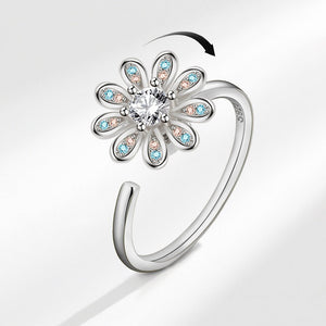 Silver ring with floral design and gemstones on a white background