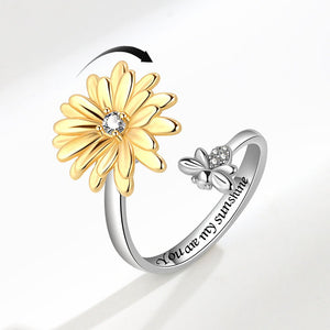Ring with gold flower and silver butterfly design on a white background