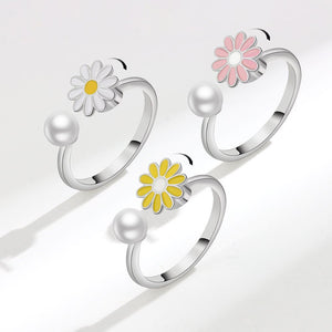 Three silver rings with floral designs on a light gray background