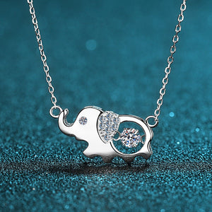 Silver elephant necklace with heart and diamond on a blue glittery background
