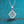 Silver necklace with a diamond pendant on a blue glittery background