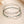 Three silver bracelets with green braided straps on a beige background