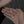 Hand holding a pearl necklace with silver chain on a gray background