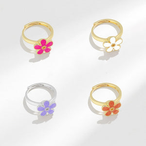 Four floral hoop earrings in gold, silver, and rose gold on a white background