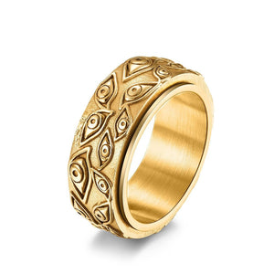 Gold evil eye spinner band ring on a white surface