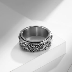 Silver evil eye spinner band ring on a white surface