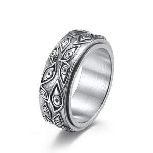 Silver evil eye spinner band ring on a white surface