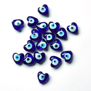 Blue heart-shaped evil eye beads on a white background