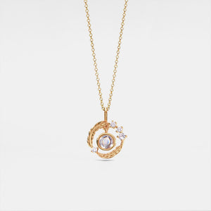 Gold necklace with a pendant on a light gray background