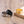 Three rings in gold, black, and silver on a wooden surface