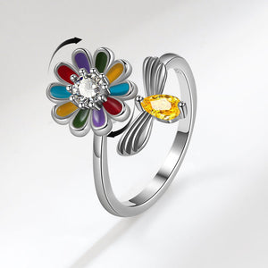 Silver ring with a colorful flower-shaped gem on a white background