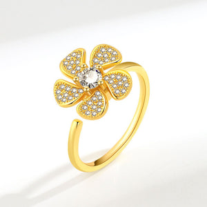 Gold flower-shaped ring with diamonds on a white background