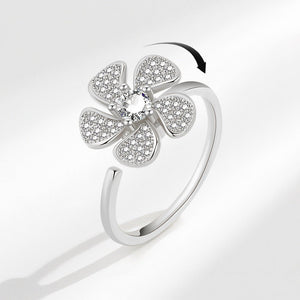 A gold-plated, adjustable ring with a flower-shaped top adorned with cubic zirconia.