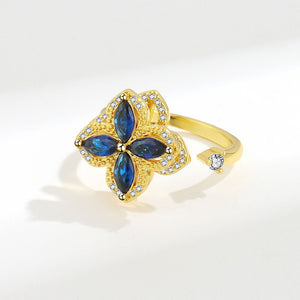 Gold ring with blue gemstones on a white background