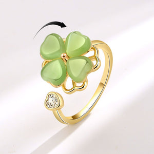 Gold ring with green four-leaf clover design on a white background