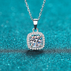Silver necklace with a diamond pendant on a teal background