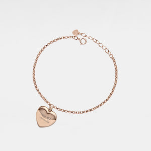 Rose gold bracelet with a heart-shaped locket on a light gray background