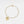 Gold bracelet with a heart-shaped locket on a light gray background