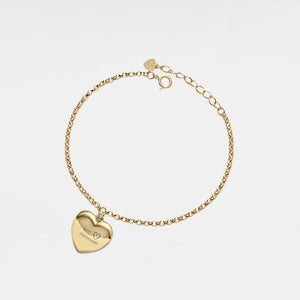 Gold bracelet with a heart-shaped locket on a light gray background