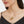 Gold heart locket necklace shown open, worn on a delicate chain on a model’s neck.