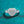 Diamond ring with heart-shaped center on a teal background